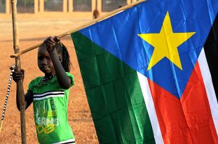 800px-A_young_girl_hangs_the_South_Sudan_flag_(5925619011)