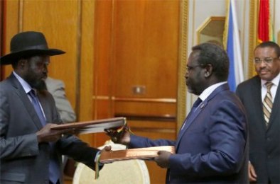 Ethiopian prime minister Hailemariam Desalegn (R) looks on as South Sudan’s Riek Machar (C) and Salva Kiir (L) exchange signed peace agreement documents in the Ethiopian capital, Addis Ababa, on 9 May 2014 (Photo: Reuters/Goran Tomasevic)