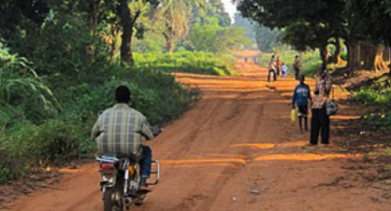 Tension in Maridi as residents flee the town after the soldiers killed two young people...In the photo, A man on a motorbike passes people collecting water in Maridi. (Photo: Maggie Fick, enhanced by Nyamile)
