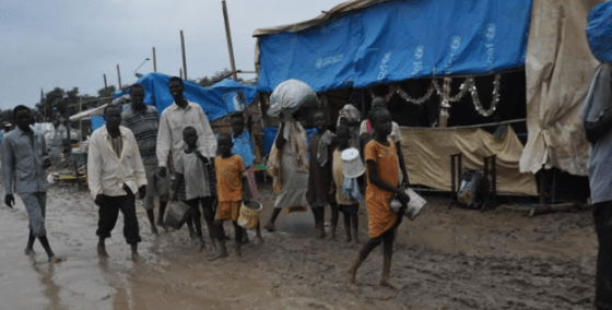 People walk along dirt roads that have been turned into streams of mud by the rains, in the UNMISS base in Malakal, South Sudan, where 19,000 people have sought shelter from months of fighting(Photo credits: Mugume Davis Rwakaringi)