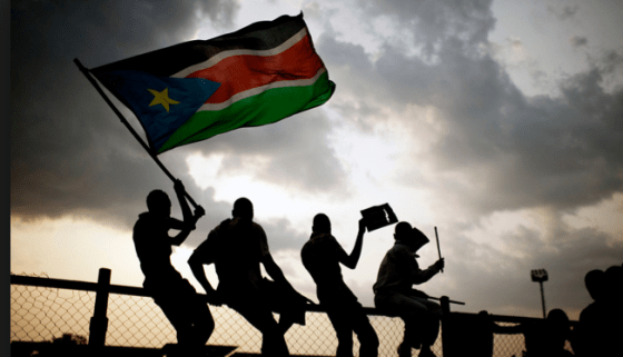South Sudanese posting with a flag anticiparting the independent of South Sudan(photo: nyamilepedia)