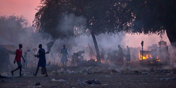 An armed man, left, walks as displaced people who fled fighting between allied forces backing South Sudan government and a break away SPLA forces in Bor by boat across the White Nile, prepare to sleep in the open at night in the town of Awerial, South Sudan Wednesday, 2014. (Photo: AP/Ben Curtis)