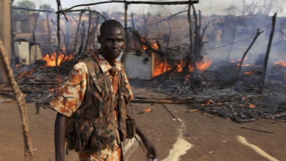 A policeman walks past the smouldering remains of a market in Rubkona near Bentiu in South Sudan on Monday. (Michael Onyiego/Associated Press)